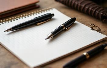 Arrangement of high-quality stationery items like leather-bound notebooks and fountain pens
